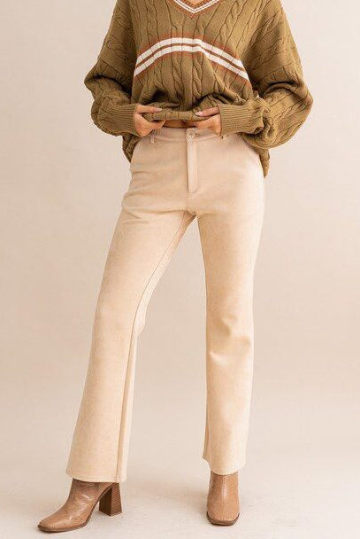 Beige suede pants and brown sweater.