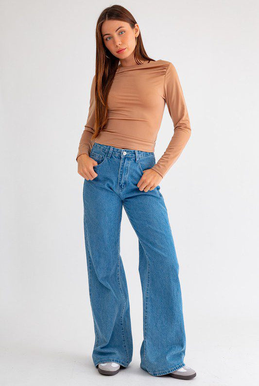 Woman in brown top and blue jeans.