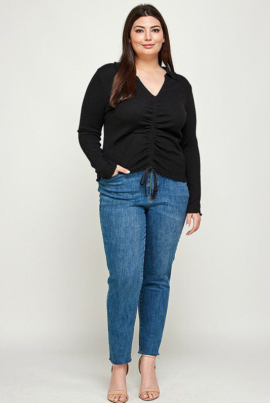 Plus-size model in black top and jeans.