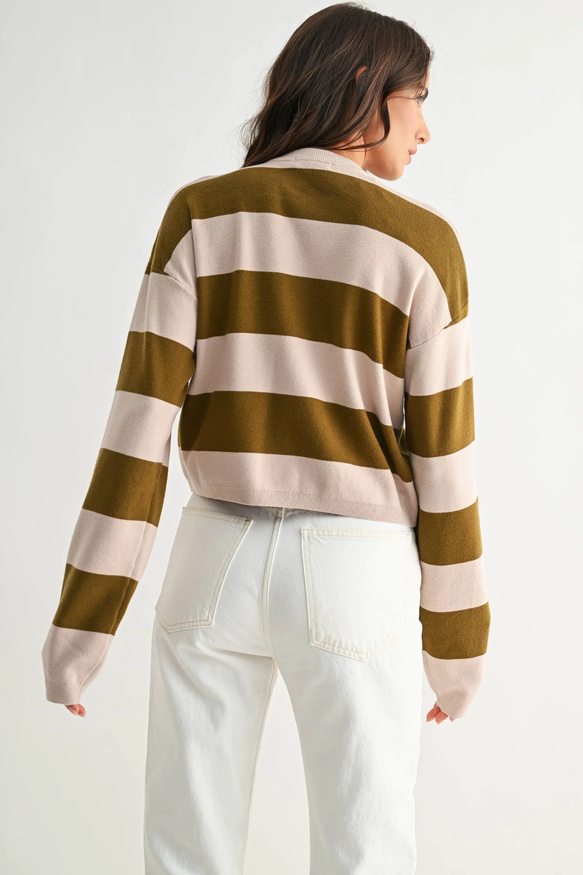 Back view of a woman wearing a light taupe and olive bold stripe crewneck sweater.