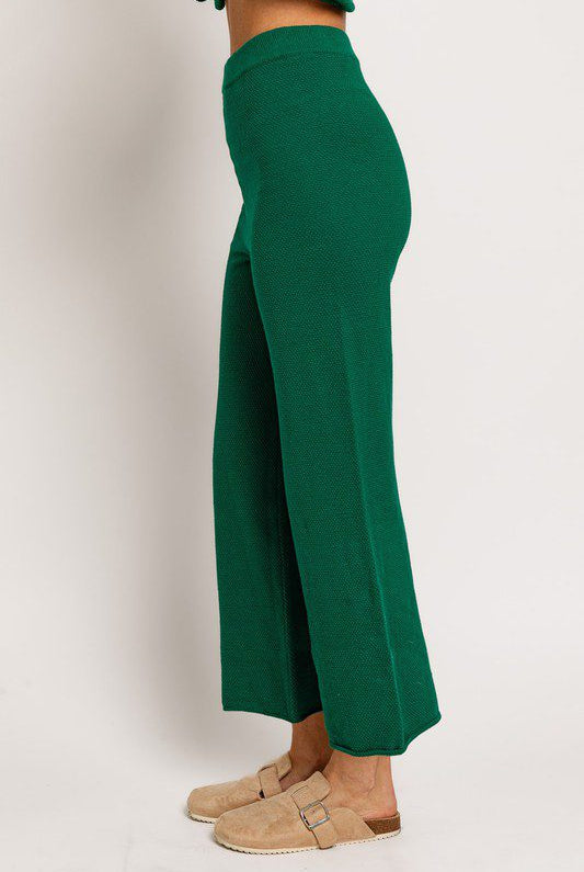 Woman in emerald green wide-leg pants.