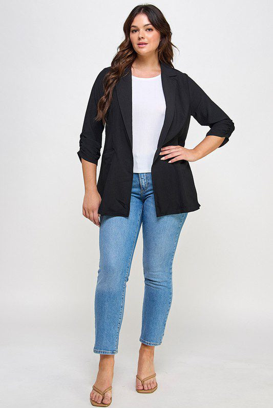 Woman in black blazer and jeans.