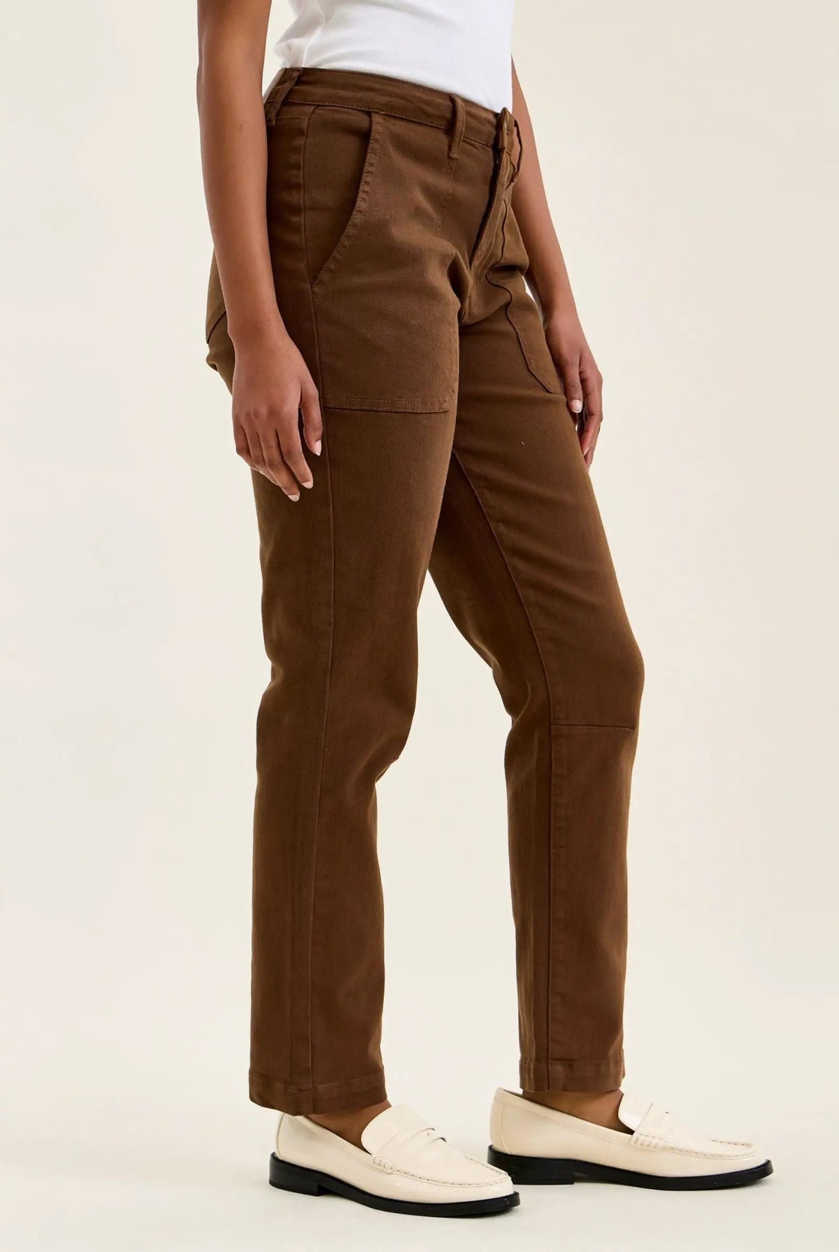 High-waist mahogany stretch jeans with slim straight legs, featuring knee darts and a double-rolled cuff for a tailored fit.