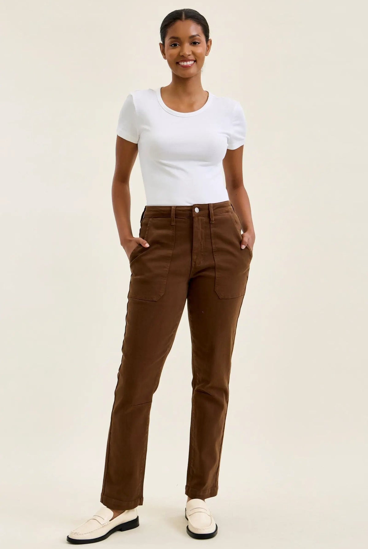 High-waist mahogany stretch jeans with slim straight leg, featuring a fitted top block, double-rolled cuff, and knee darts for a tailored shape.