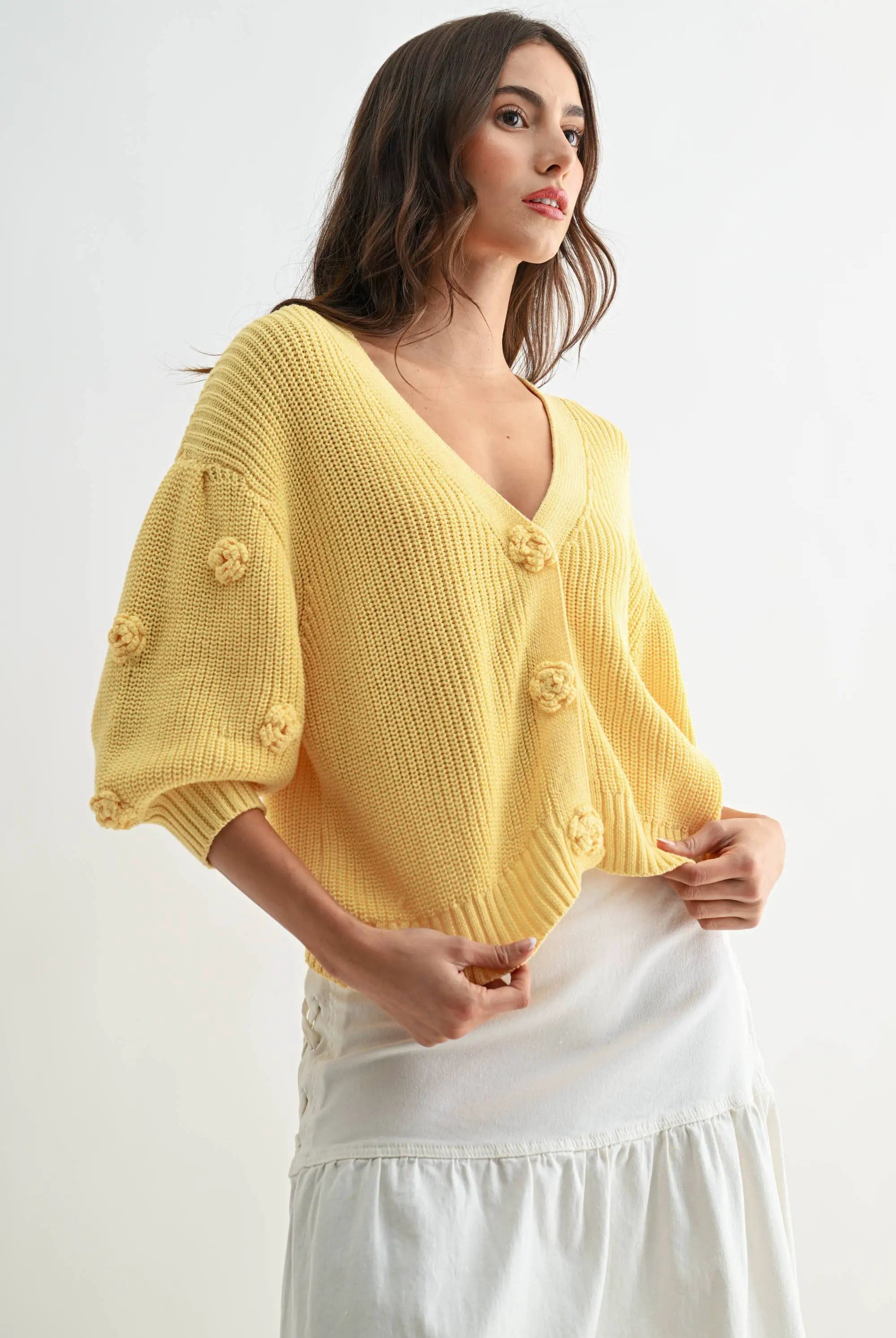Textured LT.YELLOW knit cardigan with 3D floral buttons, worn by a woman.
