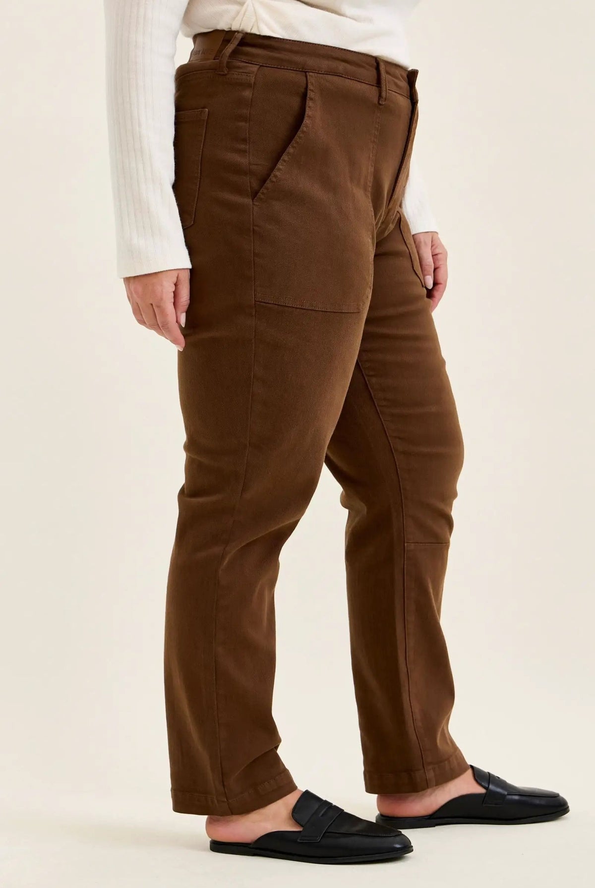 Mahogany high-waist plus stretch jeans with slim-straight leg, utility pockets, and rolled cuffs paired with black mules.