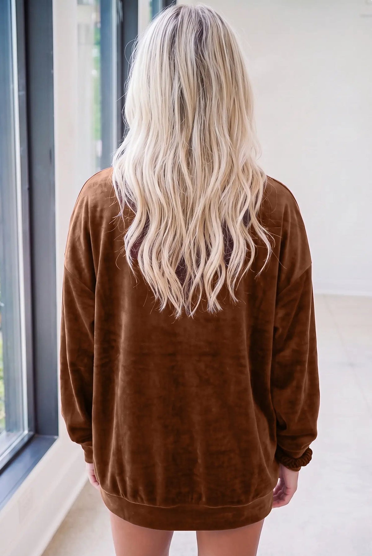 Back view of a woman with long blonde hair wearing a deep coffee velvet sweatshirt for a cozy Southern style.