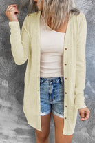 Woman wearing beige cardigan over white tee and jean shorts