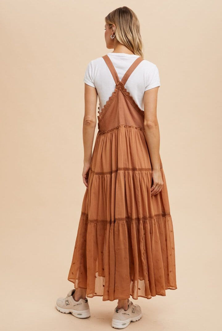 A woman wearing an orange dress and white shirt.