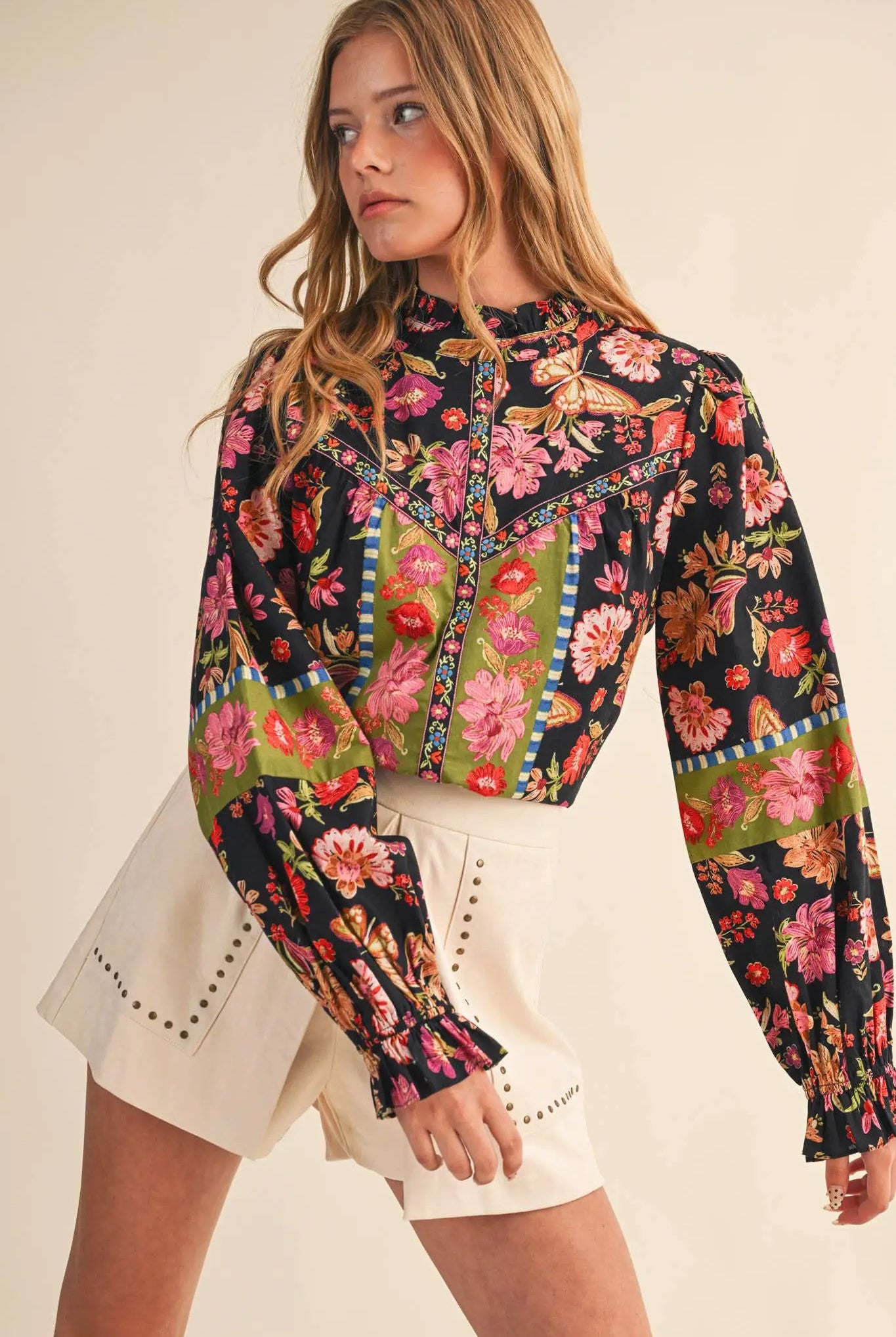 Midnight Garden Heirloom Floral Blouse featuring a black multi-floral print, green panels, and butterfly motifs on long bishop sleeves.