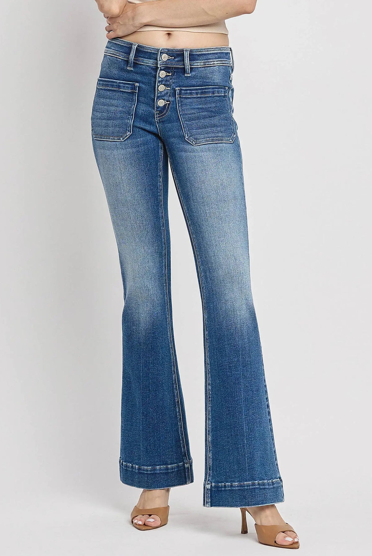 Vervet Alison mid-rise flare jeans features a button fly, patch pockets, and pleat cuffed trouser hem in Gleefully blue denim.