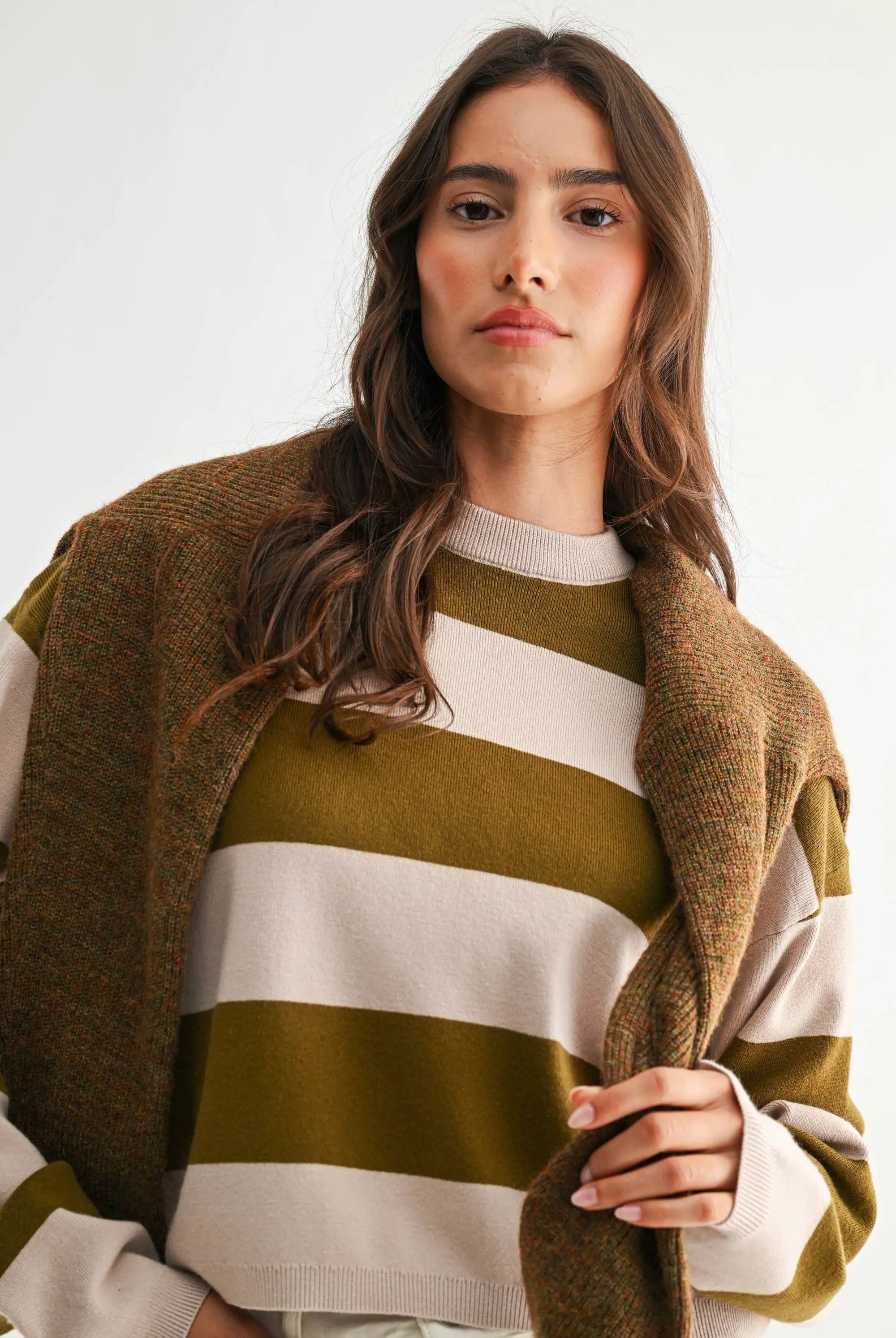 Light taupe and olive lightweight bold stripe crewneck sweater on model with brown tweed coat.