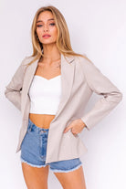 Beige blazer with denim shorts.