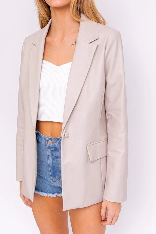 Beige blazer with single button.