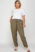 Woman in white shirt and olive green pants.