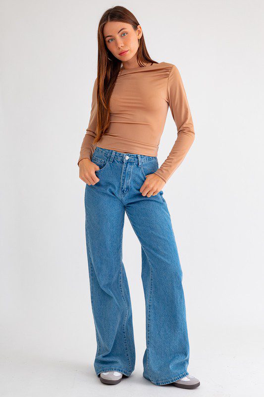 Woman in brown top and blue jeans.