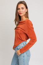 Woman in burnt orange cowl neck top.