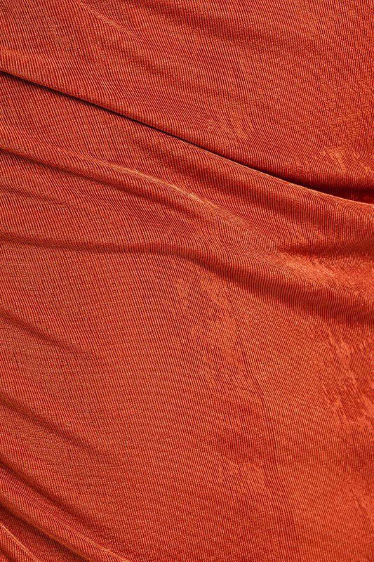 Here's an alt tag for the image: Rust-colored textured fabric.