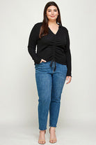 Plus-size model in black top and jeans.