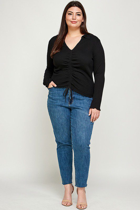 Plus-size model in black top and jeans.