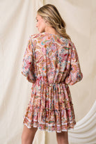 The Western Paisley Tier Dress shown from back in pink paisley floral print with a tiered silhouette and lace trim.