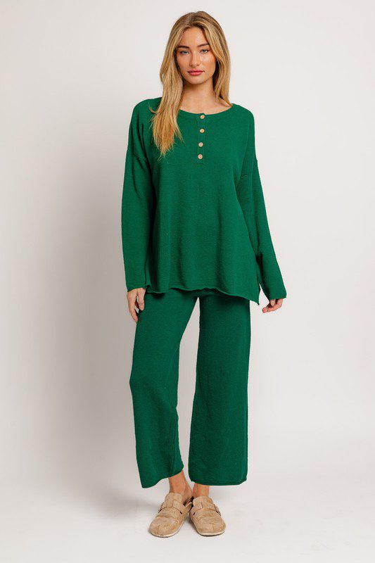 Woman in emerald green knit pantsuit.