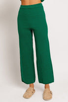 Green knit wide-leg pants and sandals.