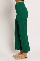 Woman in emerald green wide-leg pants.