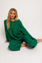 Woman in green knit sweater and pants.