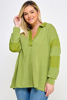 Here's an alt tag for the image: Green collared knit top with elbow patches.