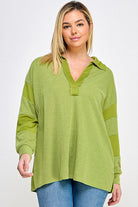 Woman in green collared long sleeve top.