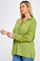 Green long-sleeve collared shirt.