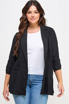 Woman in black blazer and jeans.