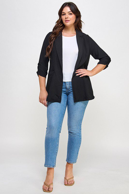 Woman in black blazer and jeans.