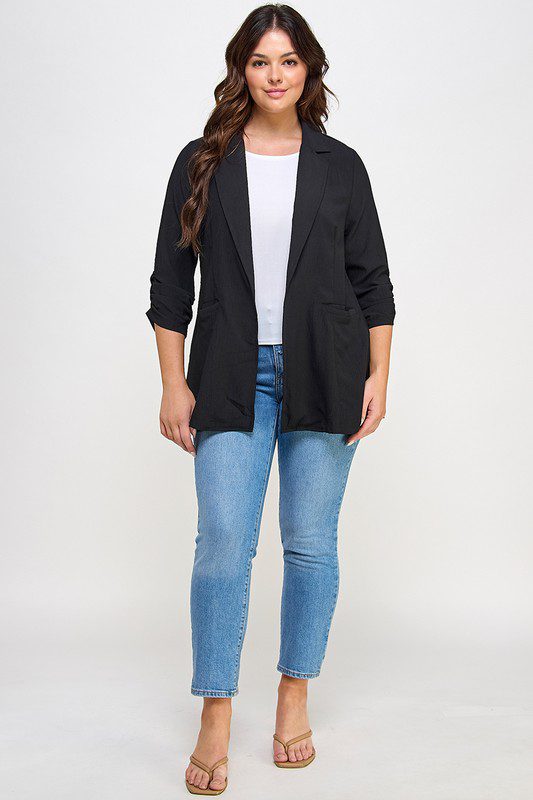 Woman in black blazer and jeans.