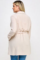 Beige cinched waist long sleeve jacket.