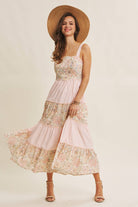 Woman wearing a floral dress and straw hat on a beige background