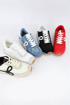 Retro low-top sneakers in black, cream, blue denim, and red. Features distinct side loops, lace-up closure, and gum soles for casual everyday wear.
