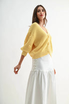 Model wearing LT.YELLOW textured knit cardigan with 3D button details and floral accents