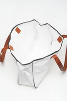 A white bag with brown handles and an orange handle.