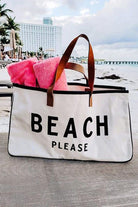 A beach bag with towels on the ground.