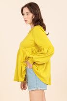 A woman wearing a yellow shirt and jeans.