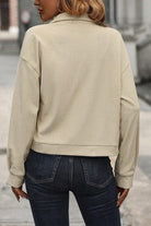 A person wearing jeans and a beige jacket.