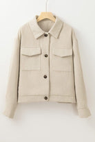 A beige jacket with two pockets and buttons.