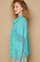 Teal lace-trimmed button-up shirt.