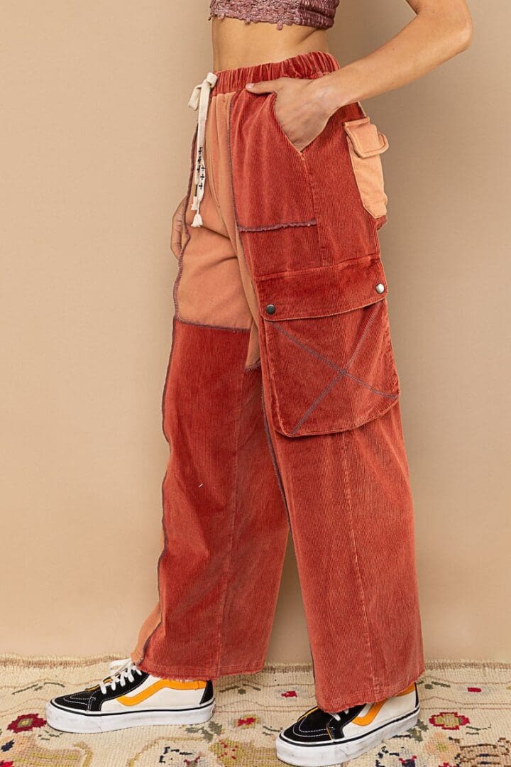 Red corduroy cargo pants with patches.