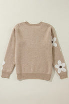 A sweater with white flowers on it.