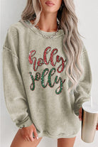 A woman wearing a sweatshirt that says " holly jolly ".