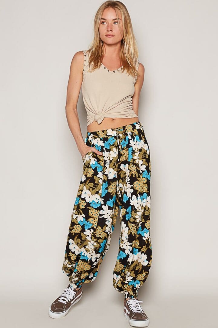 Woman in floral pants and studded top.