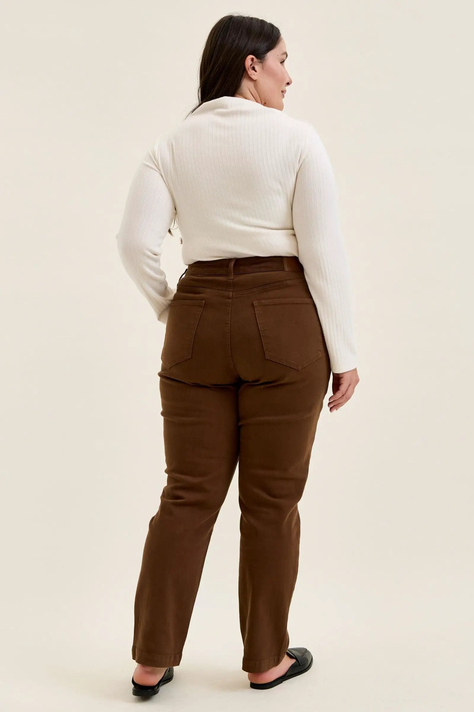 Back view of mahogany high-waist plus stretch jeans featuring classic utility pockets and a slim-straight leg fit.